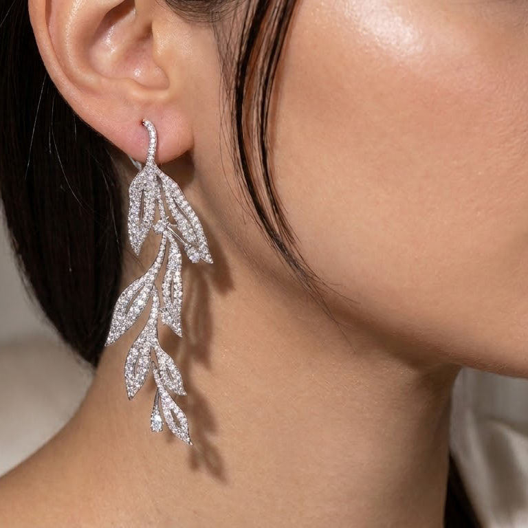 leaf shaped diamond earrings on a woman