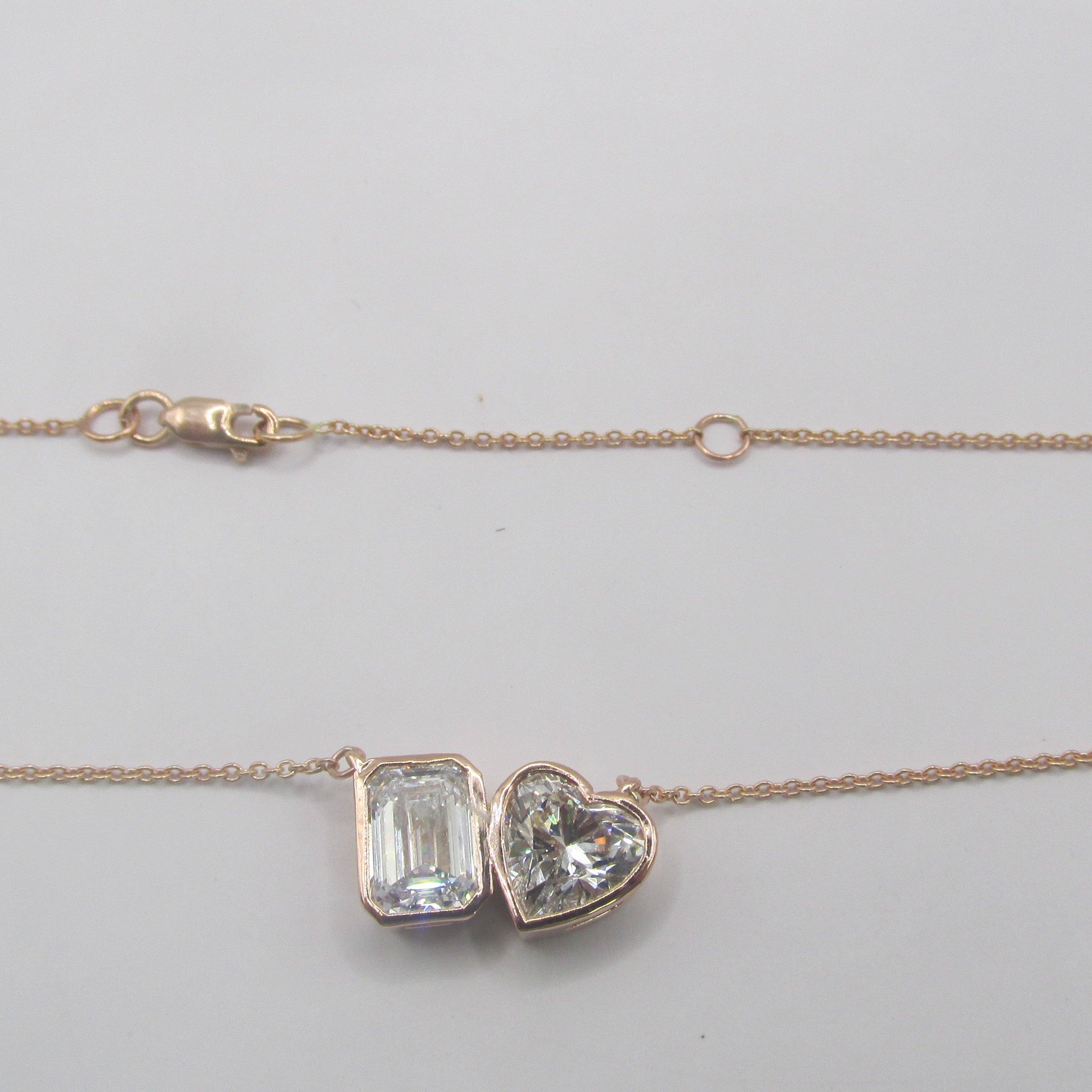 Close-up of a 2.87 carat total weight (CTW) Lab-Grown Diamond Toi et Moi Necklace set in 14K Rose Gold, featuring two distinct cuts of diamond (e.g., pear and cushion) side-by-side, symbolizing two souls