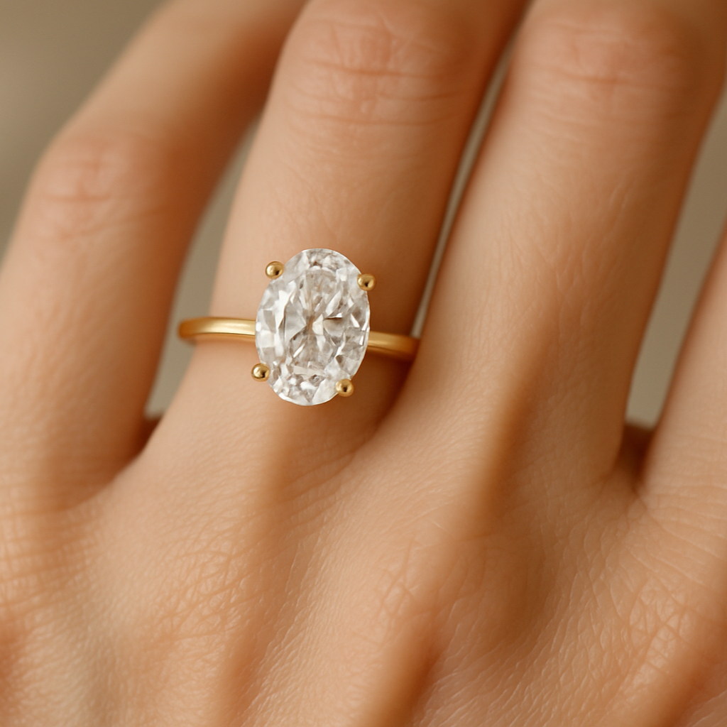 oval solitaire engagement ring  yellow gold on womans finger